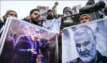  ?? Tauseef Mustafa/AFP via Getty Images ?? Protesters shout slogans against the United States and Israel as they hold posters with the image of top Iranian commander Qassem Soleimani and Iranian President Hassan Rouhani on Friday in Magam, Kashmir.