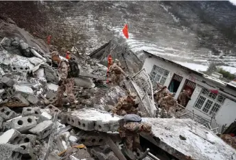  ?? ?? Military personnel and rescue workers search for missing victims following a landslide in Liangshui village at Zhaotong. — AFP photo