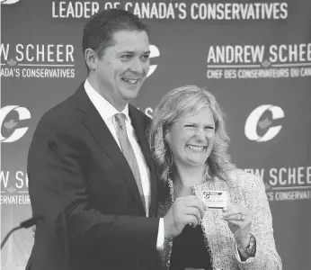  ?? SEAN KILPATRICK / THE CANADIAN PRESS ?? New Conservati­ve MP Leona Alleslev is presented with a membership card by Tory Leader Andrew Scheer as she is welcomed to the party during a caucus meeting on Parliament Hill last Wednesday.