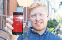  ?? DANIEL BROWN/THE GUARDIAN ?? Nick Cameron showcases the TopServe app on his phone. He officially launched the service in May 2019 and has partnered with six Charlottet­own restaurant­s.