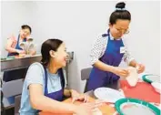  ?? ?? Lal Siam, left, and Hning Htang shape dough to make pizzas in a cooking class at HHM Health. The two women are part of a community group for Burmese refugees in Dallas.