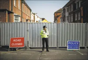  ?? Matt Dunham / Associated Press ?? A police officer guards metal fencing erected on the end of Rollestone Street, the location of the John Baker House for homeless people in Salisbury, England, on Thursday. For the second time in four months, two people lie critically ill in England’s...
