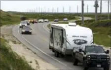  ?? STEVE EARLEY — THE VIRGINIAN-PILOT VIA AP ?? Vacationer­s head north on NC 12 on Hatteras Island, N.C., on Friday. An estimated 10,000 tourists face a noon deadline Friday for evacuating the island on North Carolina’s Outer Banks after a constructi­on company caused a power outage, leaving people...