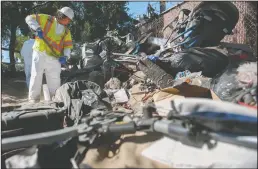  ??  ?? RAH Environmen­tal Inc.’s Geovany Nazario checks the camp for fuel, paint, pesticides and biohazards like hypodermic needles before Caltrans workers clean up site.