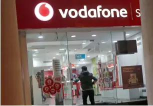  ?? Reuters ?? A customer enters a Vodafone store in New Delhi. Vodafone is in talks with Merrill Lynch, UBS and M&A boutique firm Rothschild for advisory roles. —