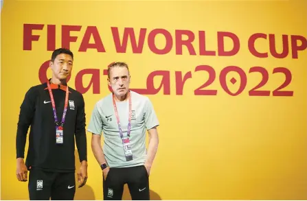  ?? Yonhap ?? South Korean national team head coach Paulo Bento, right, poses Wednesday with player Jung Woo-young, before holding a press conference in Doha, Qatar, one day ahead of their Group H match against Uruguay.
