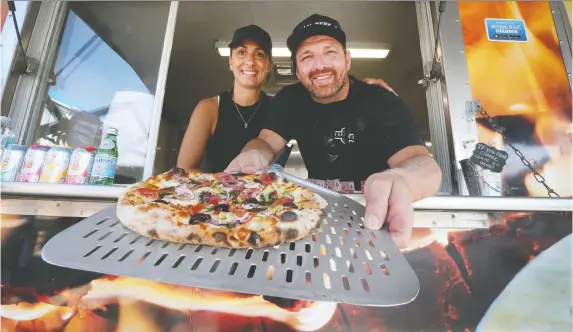  ?? TONY CALDWELL ?? Joe and Anna Crupi show off one of their wood oven pizzas at the Pizza All’Antica Food Truck in Manotick on Aug 2.