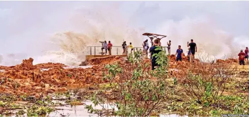  ??  ?? People watch as huge waves brought by Cyclone Veronica crashed on the coast in Port Hedland, Western Australia, on March 24, 2019, in this image obtained from social media.