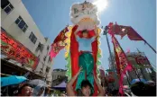  ?? — AP ?? Villagers perform lion dance during a parade on the outlying Cheung Chau island in Hong Kong to celebrate the Bun Festival on Tuesday.