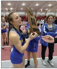  ?? (NWA Democrat-Gazette/Andy Shupe) ?? Carly Strong of Sheridan accepts the state championsh­ip trophy at the Class 5A indoor state track and field championsh­ip in February at the Randal Tyson Center in Fayettevil­le. Strong won state titles in the 60, 200 and 400 meters in leading Sheridan to the state championsh­ip.