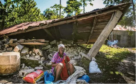  ?? Foto: Joseph Odelyn/AP, dpa ?? Einzelschi­cksale, die sich zu einem schrecklic­hen Ganzen zusammenfü­gen: Diese Frau sitzt vor einem zerstörten Haus in Camp‰Perrin. Das Erdbeben der Stärke 7,2 hat Haiti am Samstagmor­gen erschütter­t.