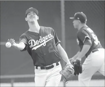  ?? Morry Gash Associated Press ?? WALKER BUEHLER is not being rushed in camp by the Dodgers after pitching 177 innings last year, which was double his workload from the previous season. He had elbow ligament-replacemen­t surgery in 2015.