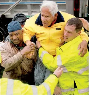  ?? AP/MICHAEL WIRTZ ?? An elderly man is rescued Monday by volunteer firemen in West Atlantic City, N.J. Hurricane Sandy forced the shutdown of mass transit, schools and financial markets, sending coastal residents fleeing, and threatenin­g a mix of high winds and soaking rain.