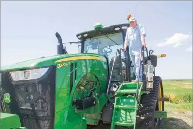  ?? MARK BUFFALO/THREE RIVERS EDITION ?? Chris Isbell of Humnoke stands on one of his John Deere tractors at his farm, Zero Grade Farms, near Humnoke. The Isbells are the 2018 Lonoke County Farm Family of the Year and the East Central District’s top farm family.