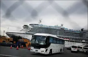  ??  ?? A bus with a driver wearing protective gear departs from the dockside next to the Diamond Princess cruise ship, which has around 3,600 people quarantine­d onboard due to fears of the new COVID-19 coronaviru­s, at the Daikoku Pier Cruise Terminal in Yokohama port yesterday.