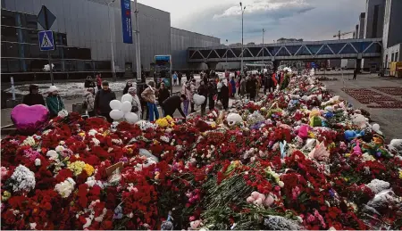  ?? Alexander Zemlianich­enko/Associated Press ?? People lay flowers and toys at a makeshift memorial in front of the Crocus City Hall on the western outskirts of Moscow on Tuesday. Russia is still reeling from the attack Friday in which gunmen killed 139 people; about 90 people remain hospitaliz­ed.