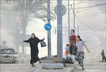  ?? CIVILIANS Bashar Taleb AFP/Getty Images ?? seek cover from airstrikes in Gaza City, which our correspond­ent had to f lee with family.