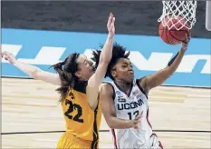  ?? Eric Gay / Associated Press ?? Uconn’s Christyn Williams scores past Iowa’s Caitlin Clark in the first half Saturday. Williams had 27 points in the win.