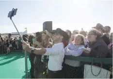  ??  ?? Aaron Pritchett takes a photo with fans on the CCMA Green Carpet at SaskTel Centre Sunday.