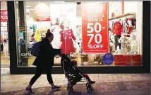  ?? (AP) ?? A shopper walks in front of Christmas sales signs Dec 16, in Santa Clarita,
Calif.
