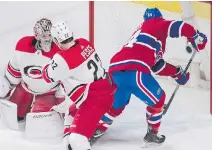  ?? GRAHAM HUGHES/THE CANADIAN PRESS ?? Charles Hudon puts the puck in behind Hurricanes goalie Cam Ward during the second period Thursday. While Hudon picked up three points, he also took the blame for the Habs’ loss, saying he missed his assignment against the Hurricanes’ Justin Williams.