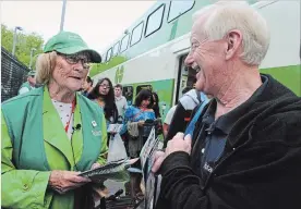  ?? PAUL FORSYTH METROLAND ?? Niagara Falls welcome team captain Barbara Burrows greets Gene Burkett of Florida as he disembarks the GO train at the Niagara Falls train station on Saturday. Burkett was in Toronto for an internatio­nal Rotary convention and was bringing his wife to...