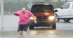  ?? — THE ASSOCIATED PRESS FILES ?? A motorist wades into a flooded street to take a photo in Brunswick, Ga., on Friday.