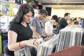  ?? AUSTIN HUMPHREYS / AMERICAN-STATESMAN ?? Kerstyn Lohr browses sections of vinyl records during Record Store Day at End of an Ear on April 19. Retail sales in April rose just 0.1 percent, after soaring to 1.5 percent in March after a harsh winter put the chill on shopping expedition­s.