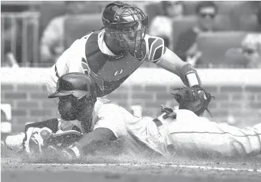  ?? Curtis Compton/Atlanta Journal-Constituti­on via AP ?? ■ Boston Red Sox’s Brandon Phillips slides home safely to score past Atlanta Braves catcher Tyler Flowers during the eighth inning of a baseball game on Wednesday in Atlanta.