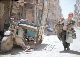  ??  ?? A boy walks along a damaged street in Douma, Damascus, Syria, on Monday. — Reuters