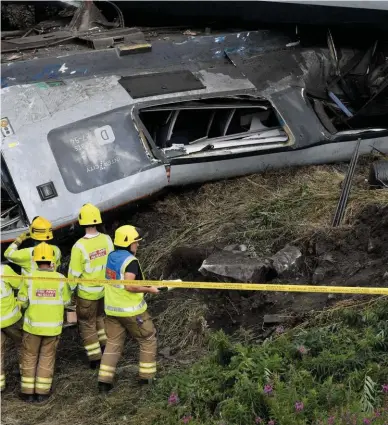  ?? PA PHOTOS. ?? Emergency services assess the accident site near Carmont on August 12, following the derailment of the 0638 Aberdeen-Glasgow, in which three people died.