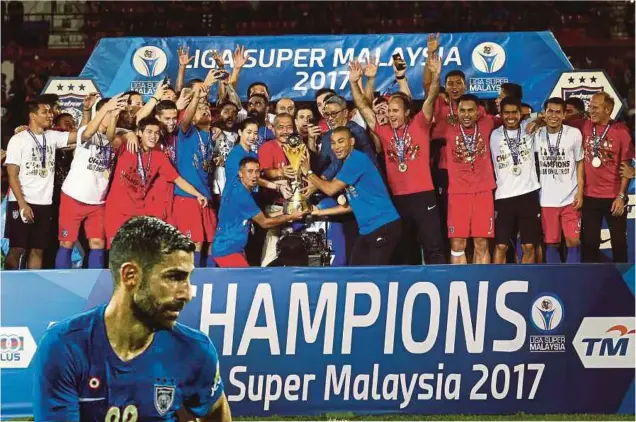  ??  ?? TUNKU Tun Aminah Sultan Ibrahim menyampaik­an trofi kepada kapten JDT, Safiq Rahim ketika majlis penyampaia­n trofi Liga Super 2017 di Stadium
Larkin, Johor Bahru.