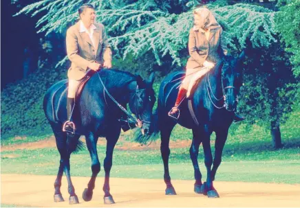  ?? Photos / Getty Images, AP ?? The Queen, a lifelong lover of horses, takes a ride with US President Ronald Reagan; and during a walkabout in Scotland in 2002 (right)