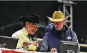  ?? Robin Jerstad / Contributo­r ?? Randy Corley, left, and Wayne Brooks work as the announcers at the rodeo.