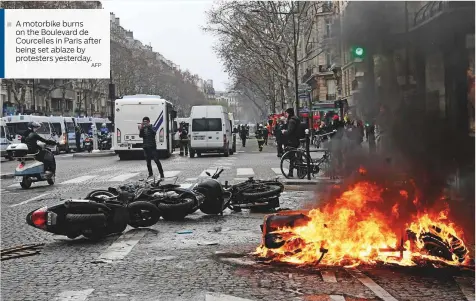  ?? AFP ?? A motorbike burns on the Boulevard de Courcelles in Paris after being set ablaze by protesters yesterday.