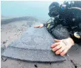  ?? ?? A diver with a decorated headstone on the 13th-century ‘Mortar Wreck’ in Poole Bay
