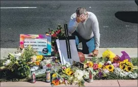  ?? Gina Ferazzi Los Angeles Times ?? A MEMORIAL has sprung up at the spot where Kurt Andras Reinhold, 42, was killed by Orange County sheriff ’s deputies. Above, Danny Blain pays his respects.