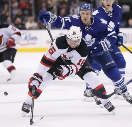  ?? STEVE RUSSELL/TORONTO STAR ?? The Leafs’ Leo Komarov does his best to confound the Devils’ Jacob Josefson during action Tuesday night at the Air Canada Centre.