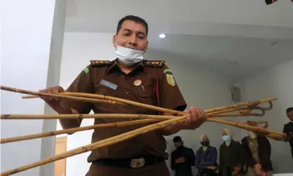  ?? Photograph: Hotli Simanjunta­k/EPA ?? An Aceh prosecutor displays the rattan rods used to cane the gay men in the Indonesian province.