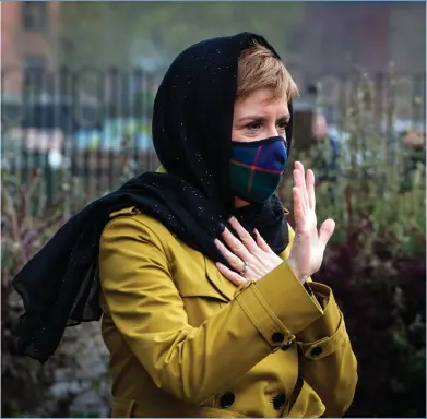  ??  ?? First Minister Nicola Sturgeon wears a face covering and a head scarf during a visit to Glasgow Central Mosque