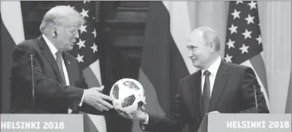  ??  ?? U.S. President Donald Trump receives a football from Russian President Vladimir Putin as they hold a joint news conference after their meeting in Helsinki, Finland July 16, 2018. REUTERS/Grigory Dukor