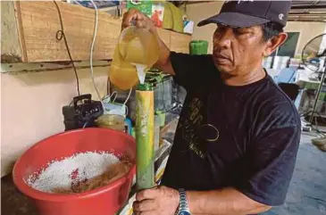  ?? BERNAMA PIC ?? Zainal Abidin Bakar preparing ‘lemang meriam’ at his stall in Kampung Pasir Putih, Ipoh, on Saturday.