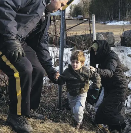  ?? TODD HEISLER / THE NEW YORK TIMES ?? A Mountie helps a family from Turkey seeking asylum in Canada on Feb. 23, part of a recent wave.