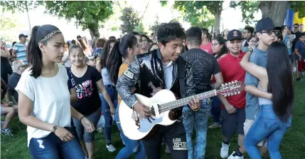  ??  ?? The lead guitarist from a local latino band leads a conga-style line of couples during the First Fridays street festival in Goshen, Ind., on June 1. AP