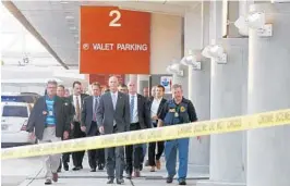  ?? WILFREDO LEE/AP ?? Florida Gov. Rick Scott, center, and law enforcemen­t officials head to a news conference outside Fort Lauderdale-Hollywood Internatio­nal Airport on Friday.