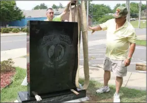  ?? The Sentinel-Record/Richard Rasmussen ?? NEW MONUMENT: Brandon Chrestman, left, with Hot Springs Monument Co., and Donald Newton, a member of the Garland County Veterans Memorial Committee, work Tuesday morning to place the new POW/MIA monument into place at the Garland County Veterans...