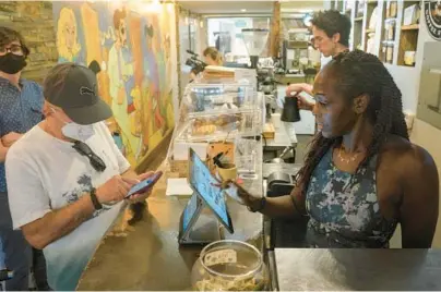  ?? BEBETO MATTHEWS/AP ?? Kymme Williams-Davis takes orders last week at the cafe she owns in the Brooklyn borough of New York City.