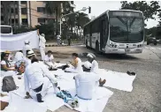  ?? CéSAR BOLíVAR ?? Los manifestan­tes almuerzan junto a un bus.