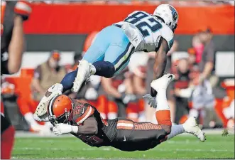  ?? ASSOCIATED PRESS] [RON SCHWANE/THE ?? Browns safety Derrick Kindred upends Titans tight end Jonnu Smith.