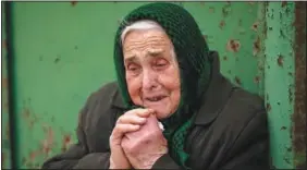  ?? ?? Olha Petrenko, 84, cries Feb. 13 as the coffin of Oleksandr Maksymenko, 38, passes by during his funeral in his home village Kniazhychi, east of Kyiv. Maksymenko, a civilian who was a volunteer in the armed forces of Ukraine, was killed in the fighting in Bakhmut area.
